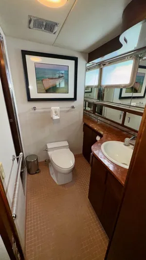 Adventurer Yacht Photos Pics Bathroom interior of 1987 Burger 86 Raised Pilothouse yacht, featuring sink, toilet, and artwork.