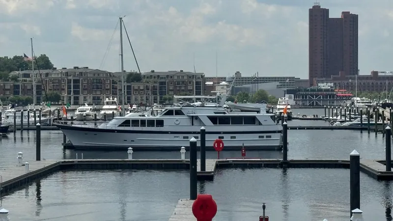 Adventurer Yacht Photos Pics 1987 Burger 86 Raised Pilothouse yacht docked in a marina with cityscape background.