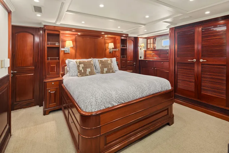 Jade Panama Yacht Photos Pics Luxurious 2001 Rayburn Flush Deck yacht bedroom with elegant wood furnishings and ambient lighting.