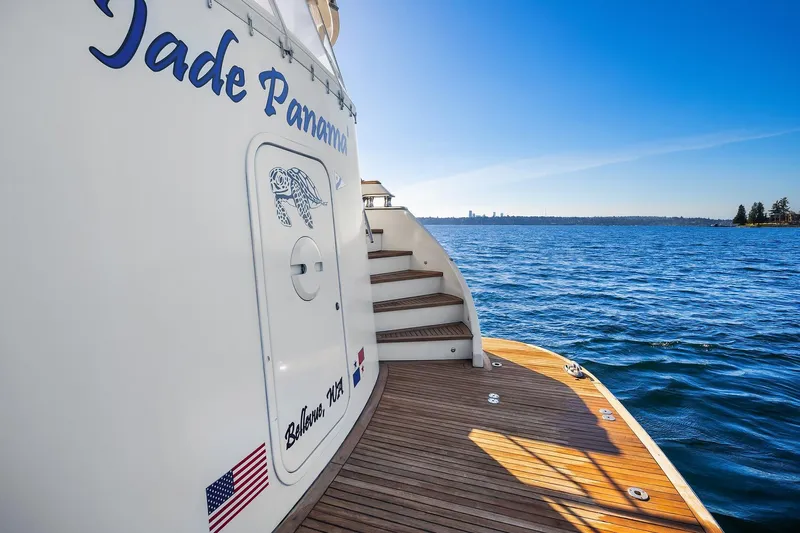 Jade Panama Yacht Photos Pics 2001 Rayburn Flush Deck yacht on open water, featuring wooden deck and clear blue sky.