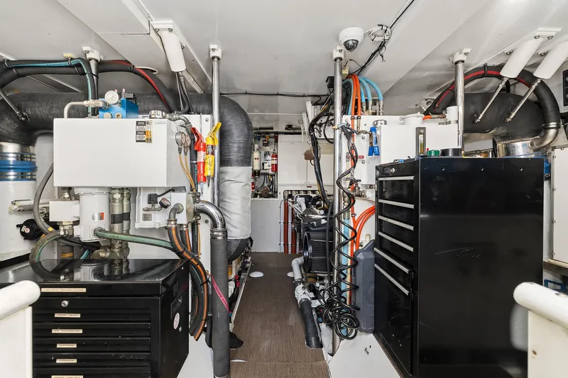 Jade Panama Yacht Photos Pics Engine room of 2001 Rayburn Flush Deck yacht with mechanical equipment and storage cabinets.