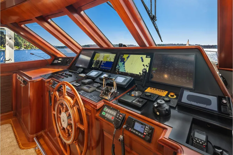 Jade Panama Yacht Photos Pics Helm of 2001 Rayburn Flush Deck yacht with navigation screens and wooden steering wheel.