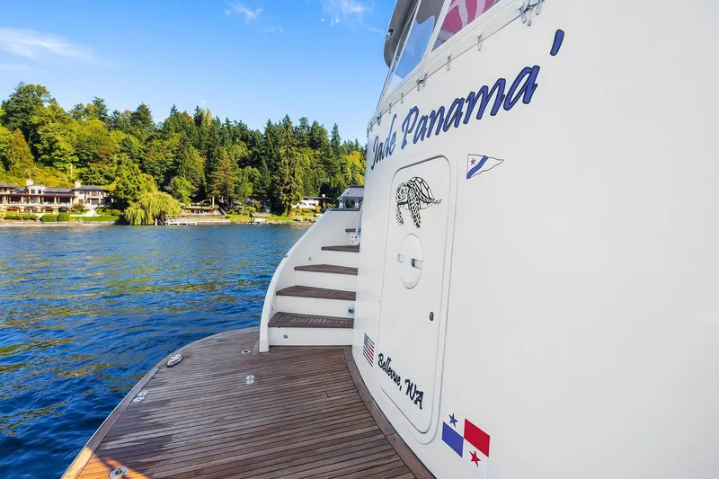 Jade Panama Yacht Photos Pics 2001 Rayburn Flush Deck yacht on serene lake with lush green shoreline.