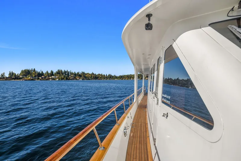 Jade Panama Yacht Photos Pics 2001 Rayburn Flush Deck yacht cruising on a serene lake with clear blue skies.