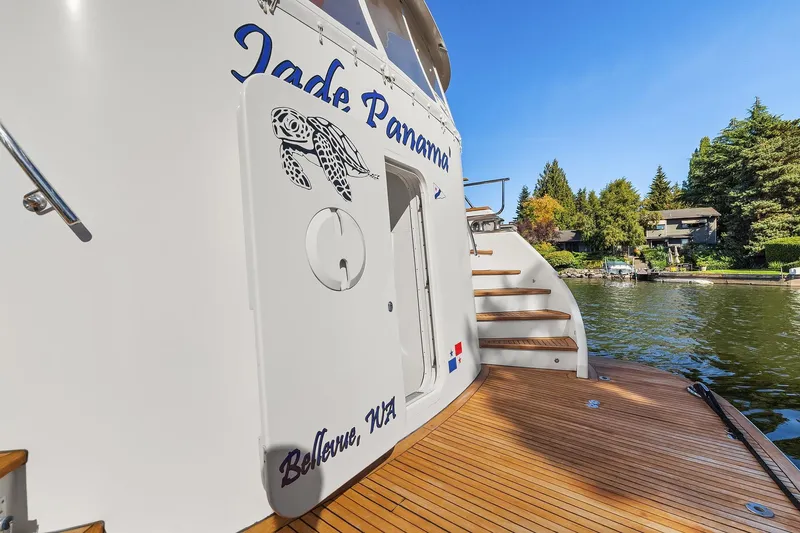 Jade Panama Yacht Photos Pics Rayburn Flush Deck 2001 yacht with turtle design, docked by scenic waterfront homes.