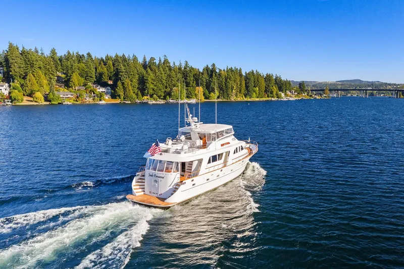 Jade Panama Yacht Photos Pics 2001 Rayburn Flush Deck yacht cruising on a scenic lake with forested shoreline.