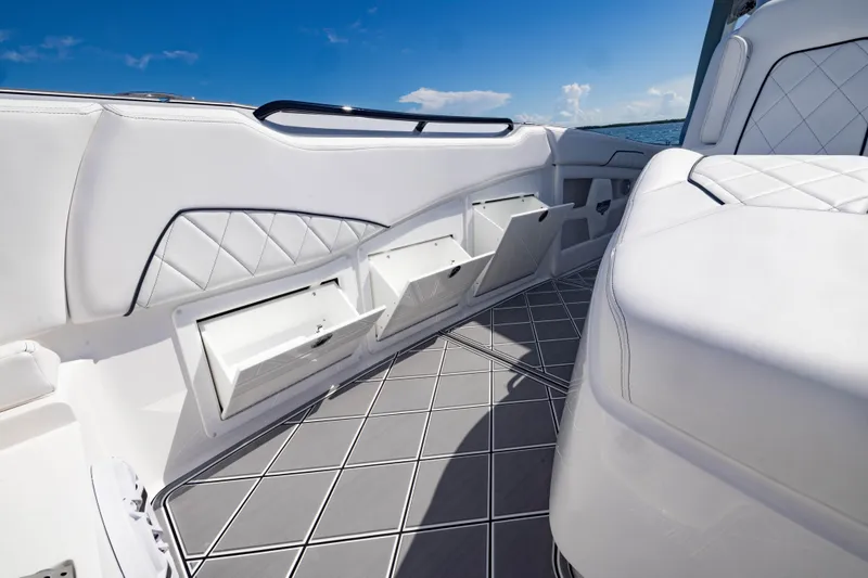  Yacht Photos Pics 2024 Deep Impact 399 Sport boat interior with white seating and storage compartments.