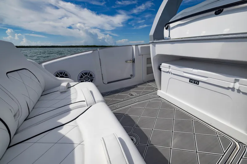  Yacht Photos Pics 2024 Deep Impact 399 Sport boat interior with luxury seating and Yeti cooler on deck.