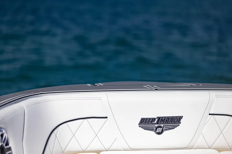  Yacht Photos Pics 2024 Deep Impact 399 Sport boat with white seating, logo visible, against a blue water backdrop.