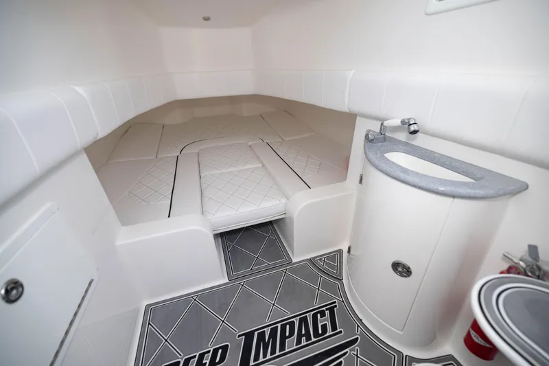  Yacht Photos Pics 2024 Deep Impact 399 Sport cabin interior with cushioned seating and compact sink area.