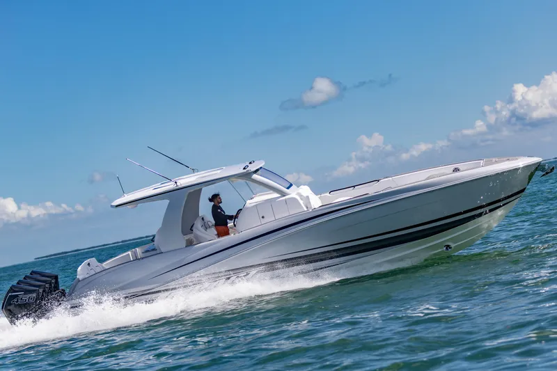  Yacht Photos Pics 2024 Deep Impact 399 Sport boat cruising on open water under a clear blue sky.