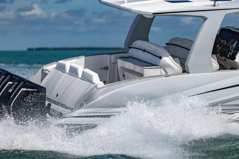  Yacht Photos Pics 2024 Deep Impact 399 Sport boat cruising on water, showcasing powerful engines and sleek design.