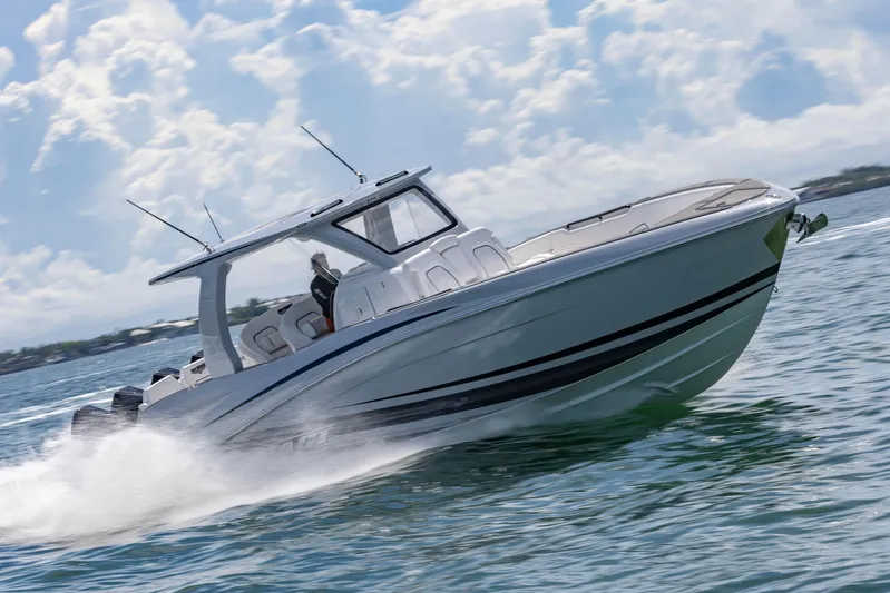  Yacht Photos Pics 2024 Deep Impact 399 Sport boat speeding on open water under a cloudy sky.