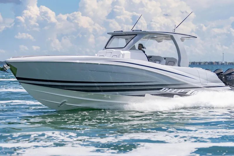  Yacht Photos Pics 2024 Deep Impact 399 Sport boat cruising on open water under a cloudy sky.