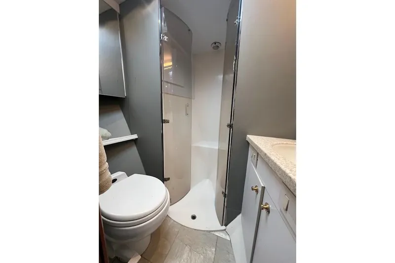 Reel Interest Yacht Photos Pics Bathroom interior of 2002 Ocean Yachts 56 Super Sport, featuring shower and toilet.