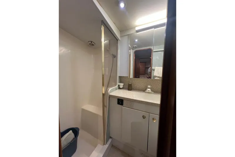 Reel Interest Yacht Photos Pics Bathroom interior of 2002 Ocean Yachts 56 Super Sport, featuring shower and vanity.