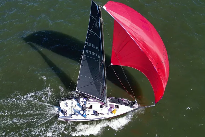 Dark Storm Yacht Photos Pics 2019 J Boats J 121 sailing with red spinnaker on open water.