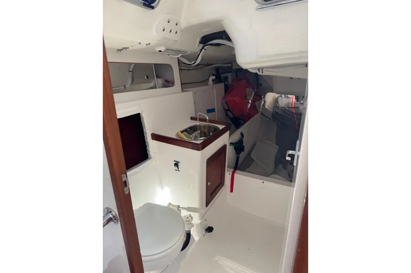 Dark Storm Yacht Photos Pics Interior of 2019 J Boats J/121 sailboat featuring compact bathroom and storage area.
