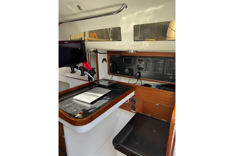 Dark Storm Yacht Photos Pics 2019 J Boats J/121 interior navigation station with control panel and equipment.