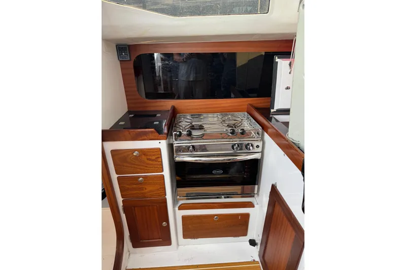 Dark Storm Yacht Photos Pics 2019 J Boats J/121 yacht interior with stove and wooden cabinetry.