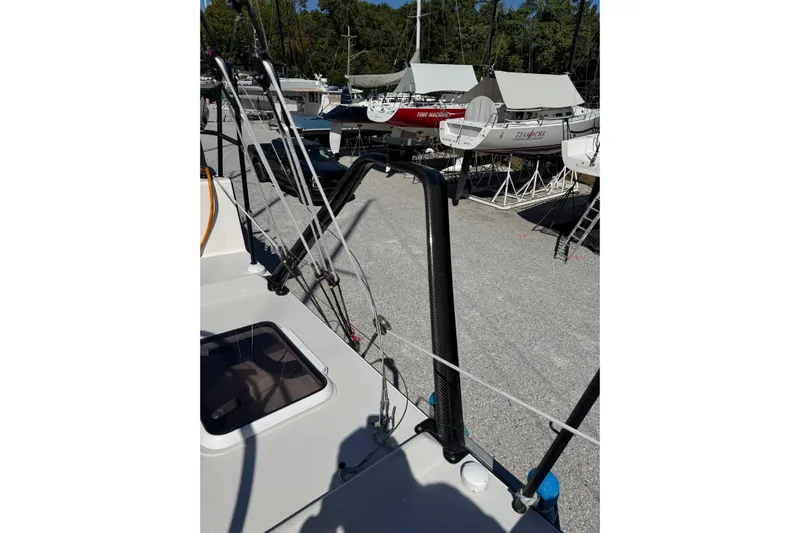 Dark Storm Yacht Photos Pics 2019 J Boats J/121 sailboat on land, surrounded by other boats and trees.