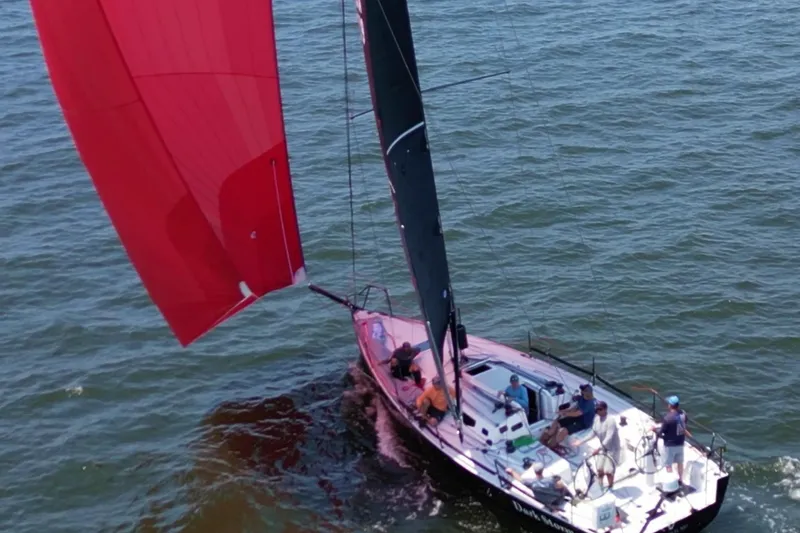 Dark Storm Yacht Photos Pics 2019 J Boats J/121 sailing with red spinnaker on open water.