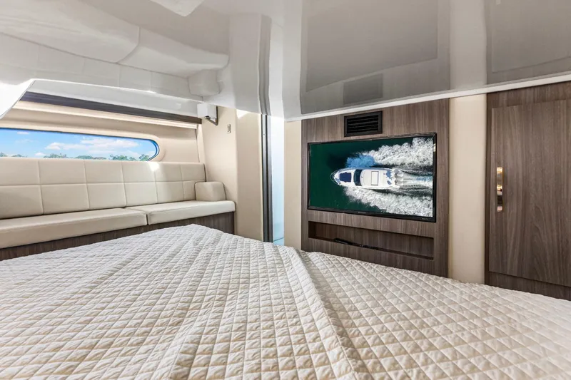  Yacht Photos Pics Luxurious interior of 2020 Regal 38 XO yacht with bed, sofa, and TV.