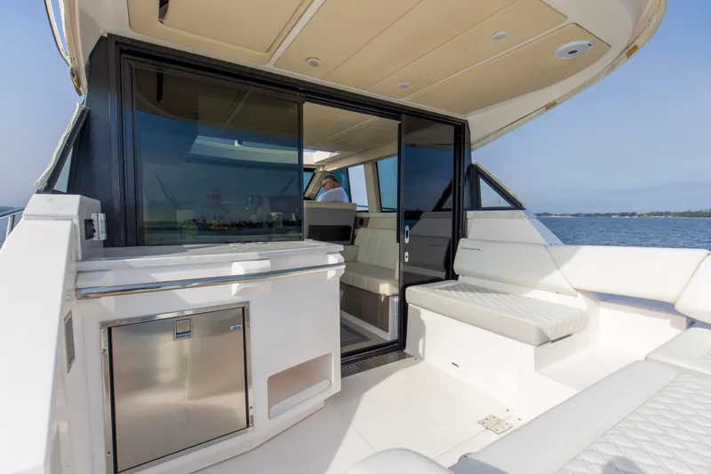  Yacht Photos Pics 2020 Regal 38 XO yacht interior with seating and sliding glass door, overlooking the water.