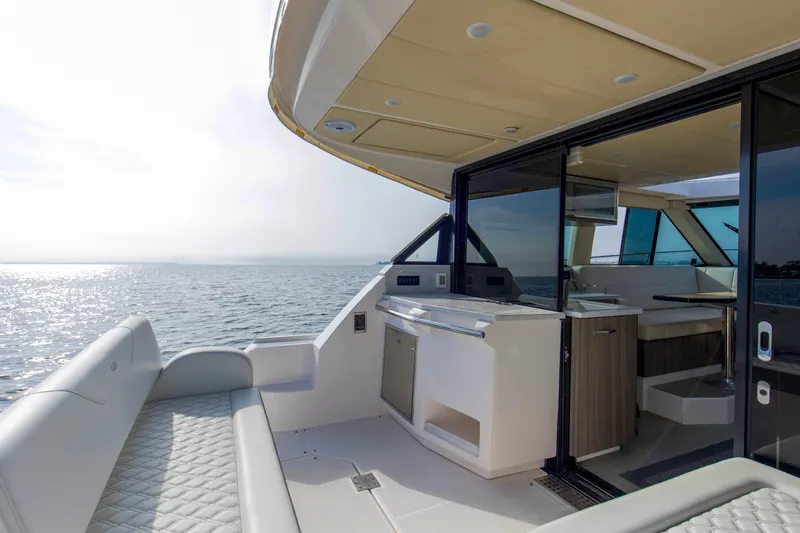  Yacht Photos Pics 2020 Regal 38 XO yacht interior with ocean view, featuring modern seating and kitchenette.