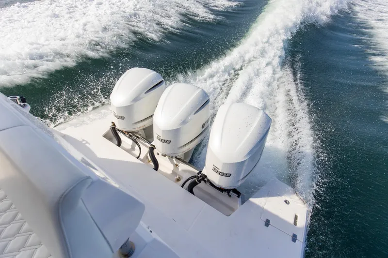  Yacht Photos Pics 2020 Regal 38 XO boat with triple outboard engines cruising on water.