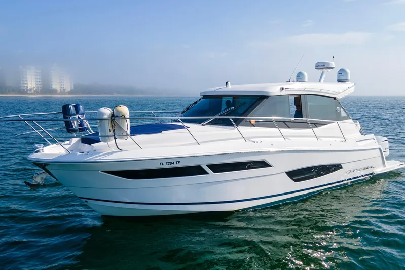  Yacht Photos Pics 2020 Regal 38 XO yacht cruising on open water with city skyline in background.