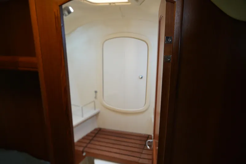 Marabelle Yacht Photos Pics Interior of 2005 Hunter 41 AC sailboat, featuring a wooden door and compact bathroom.