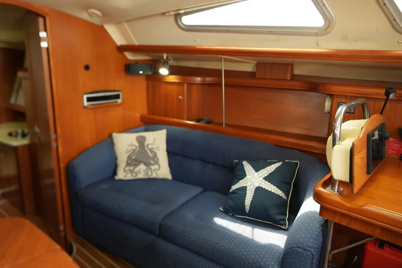 Marabelle Yacht Photos Pics Interior of 2005 Hunter 41 AC yacht with blue sofa and nautical-themed pillows.