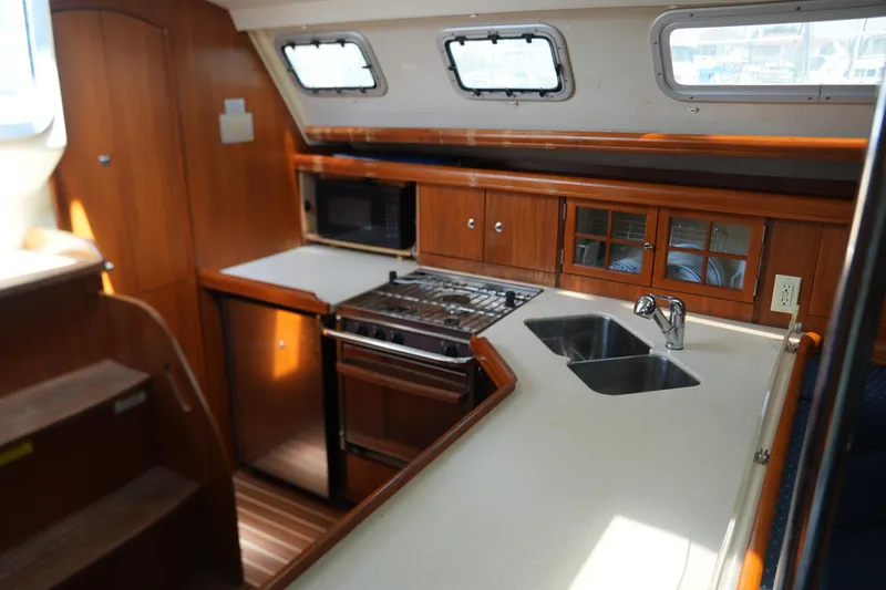 Marabelle Yacht Photos Pics Interior of 2005 Hunter 41 AC yacht kitchen with wood cabinetry and modern appliances.