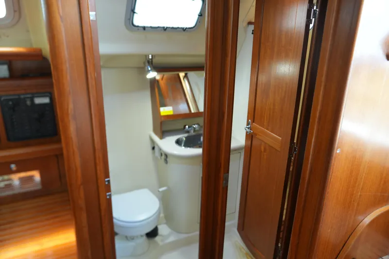 Marabelle Yacht Photos Pics Interior of 2005 Hunter 41 AC sailboat bathroom with wooden cabinetry and compact design.