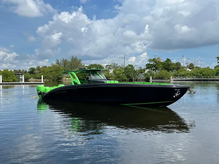  Yacht Photos Pics 2020 Midnight Express boat with green accents on calm water under a cloudy sky.