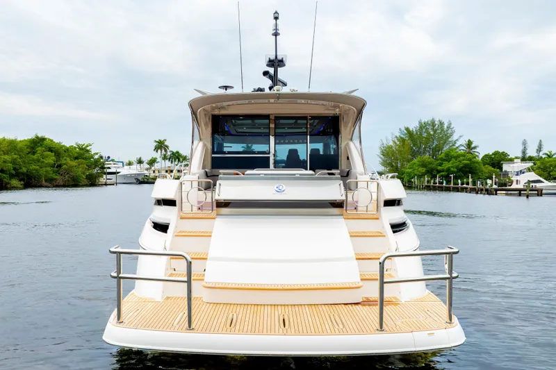  Yacht Photos Pics Riviera 6000 Sport Yacht 2026, rear view on water, showcasing elegant design and spacious deck.