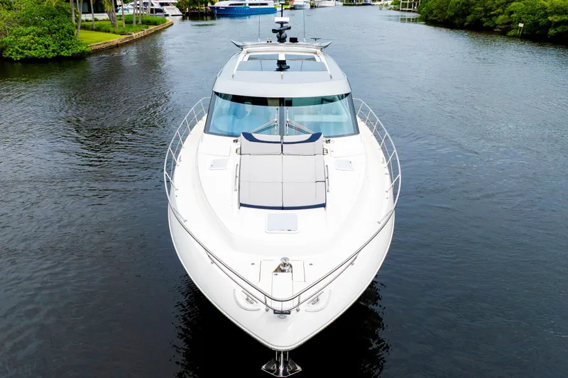  Yacht Photos Pics 2026 Riviera 6000 Sport Yacht cruising on a serene waterway, showcasing sleek design.