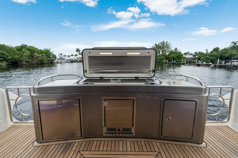  Yacht Photos Pics Outdoor kitchen on 2026 Riviera 6000 Sport Yacht, featuring stainless steel appliances and scenic water view.