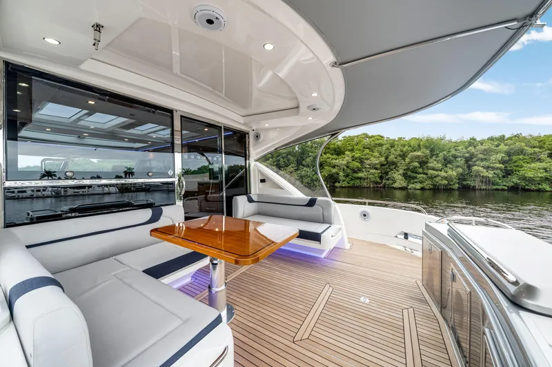  Yacht Photos Pics Luxurious 2026 Riviera 6000 Sport Yacht deck with elegant seating and scenic water view.