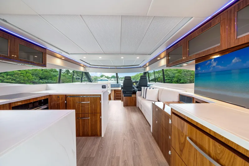  Yacht Photos Pics Luxurious interior of 2026 Riviera 6000 Sport Yacht with modern wood finishes and scenic views.