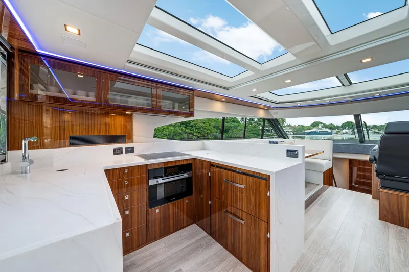  Yacht Photos Pics Luxurious interior of 2026 Riviera 6000 Sport Yacht with modern kitchen and panoramic windows.