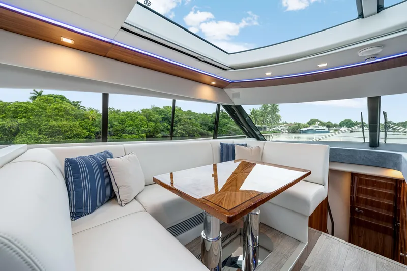  Yacht Photos Pics Luxurious interior of 2026 Riviera 6000 Sport Yacht with plush seating and panoramic windows.
