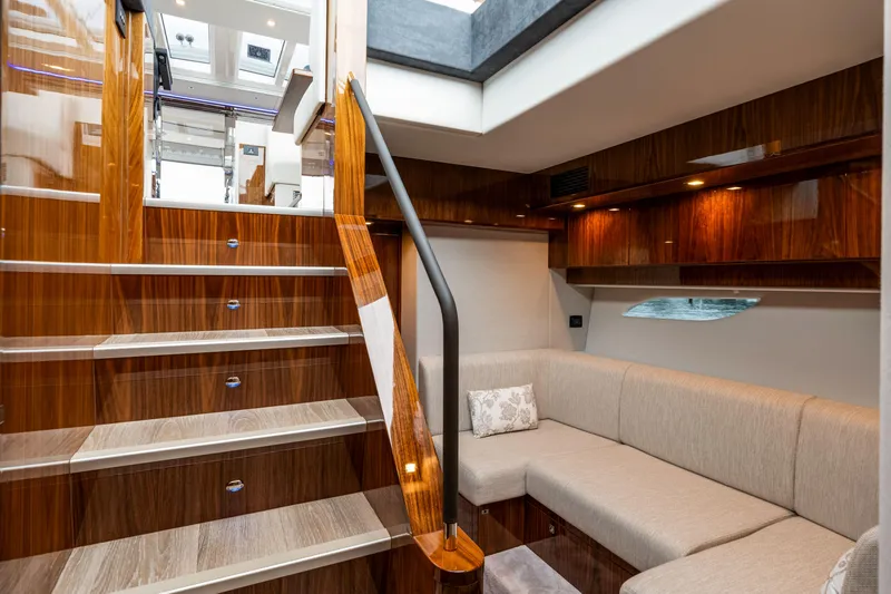  Yacht Photos Pics Luxurious interior of 2026 Riviera 6000 Sport Yacht with elegant wood finishes and plush seating.