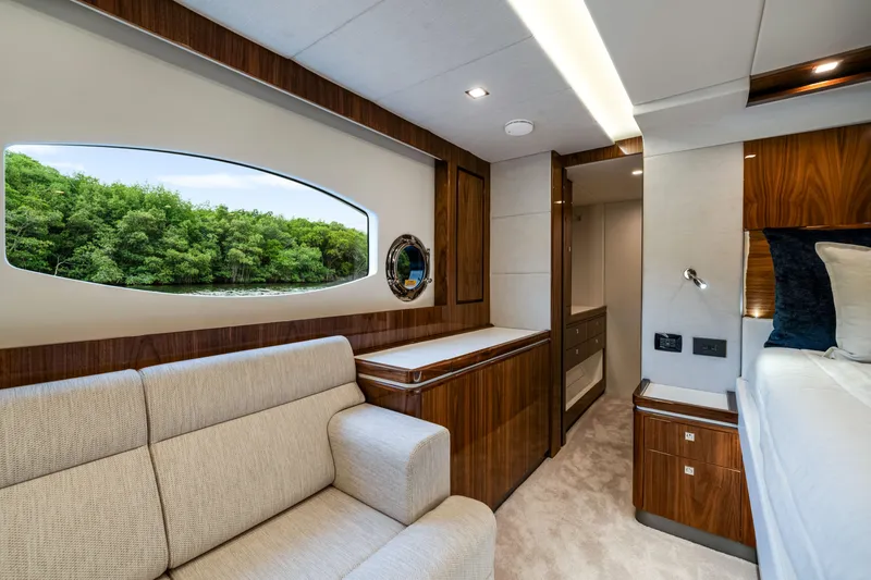  Yacht Photos Pics Luxurious interior of 2026 Riviera 6000 Sport Yacht with elegant wood finishes and scenic window view.