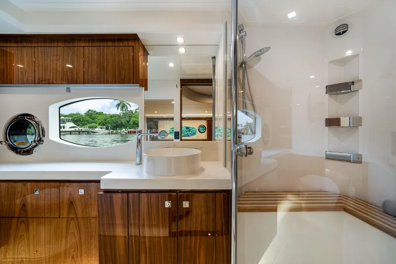  Yacht Photos Pics Luxurious bathroom interior of 2026 Riviera 6000 Sport Yacht with modern fixtures and wood accents.
