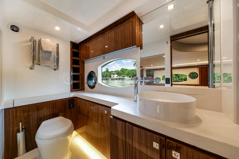  Yacht Photos Pics Luxurious bathroom in 2026 Riviera 6000 Sport Yacht with modern fixtures and scenic window view.