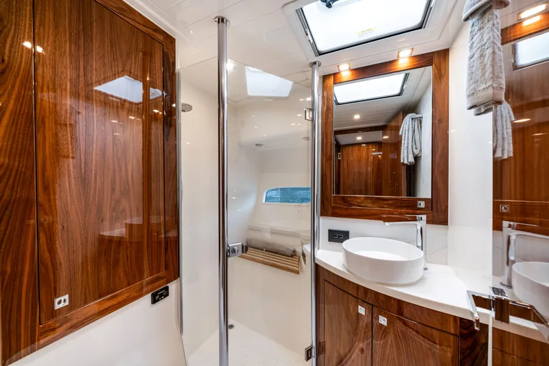  Yacht Photos Pics Luxurious bathroom interior of 2026 Riviera 6000 Sport Yacht with wood accents and modern fixtures.