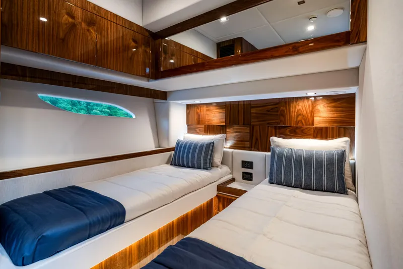  Yacht Photos Pics Luxurious cabin interior of 2026 Riviera 6000 Sport Yacht with twin beds and elegant wood finishes.