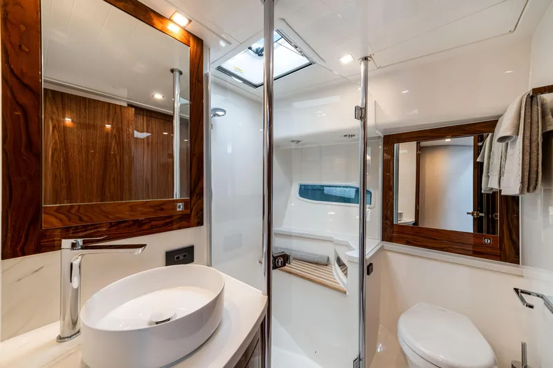  Yacht Photos Pics Luxurious bathroom in 2026 Riviera 6000 Sport Yacht with modern fixtures and elegant wood accents.